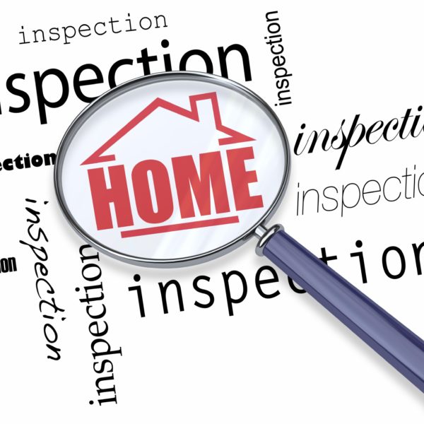 A magnifying glass hovering over the words Inspection, centering on a house with the word Home inside it