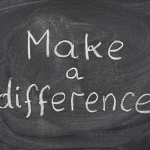 make a difference motivational phrase handwritten with white chalk on blackboard